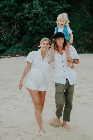 A happy beach portrait of a family walking together on sandy shores.