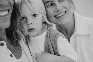A heartwarming black and white portrait showing gentle affection between parent and child.