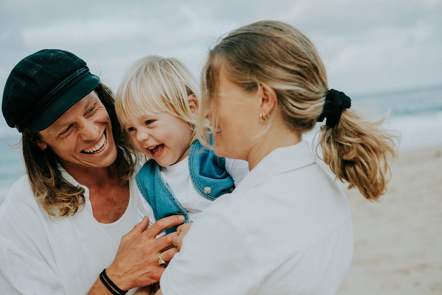 Family sharing intimate moments together on a sunny beach.
