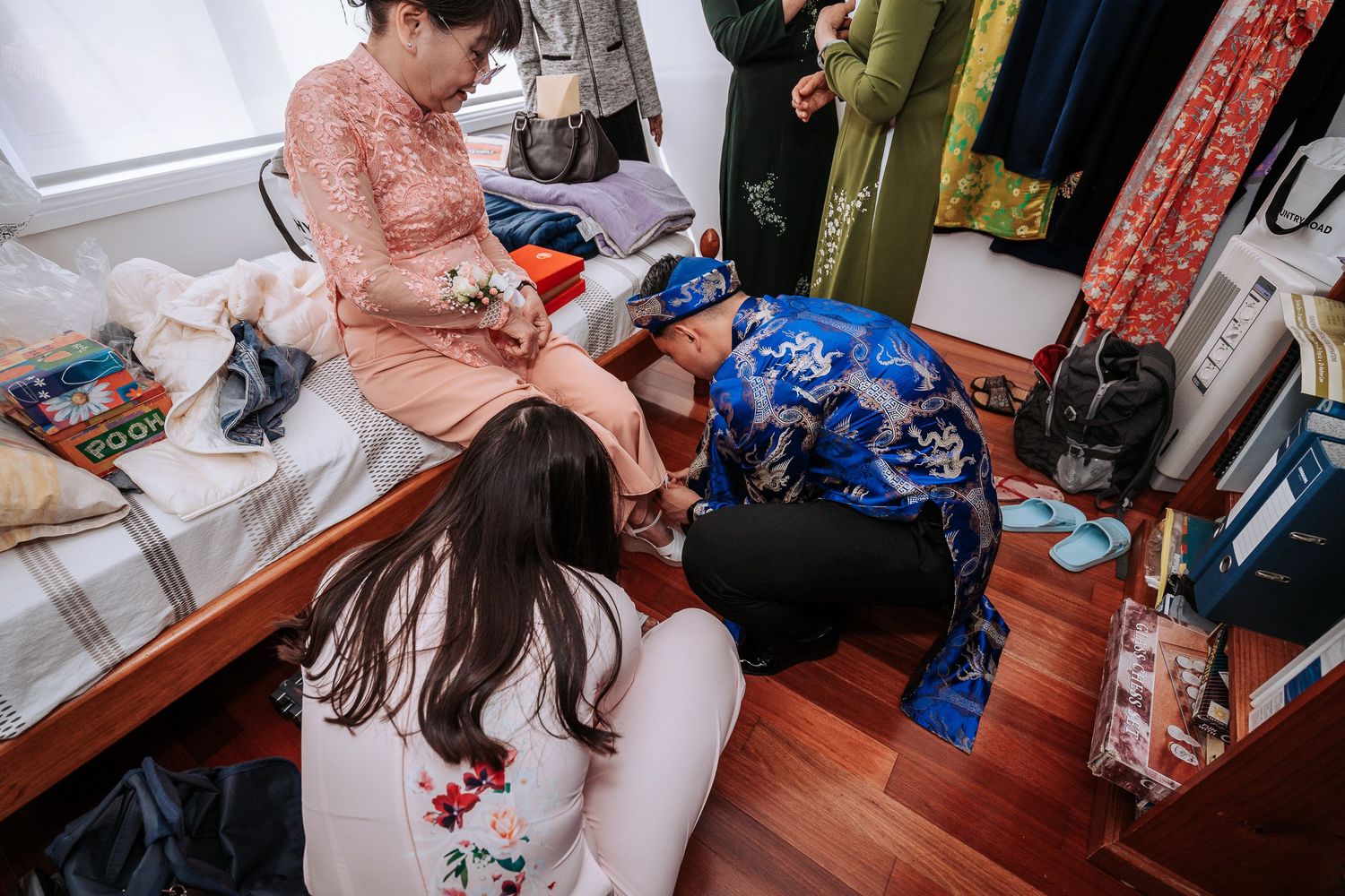 Wedding preparation scene showing dresses and accessories laid out in a room.