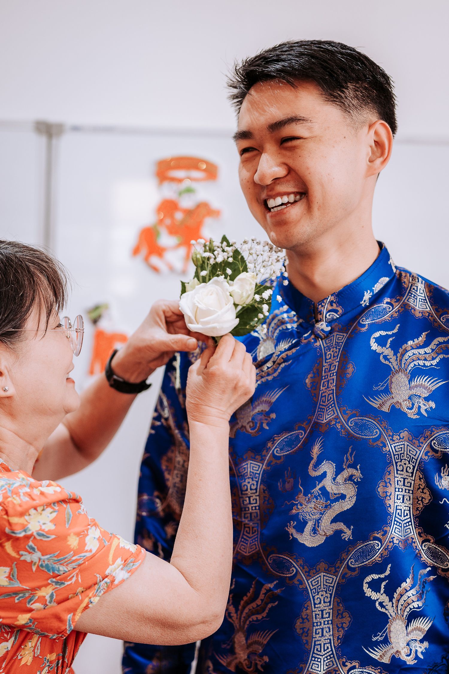 Series of photos showing couple in blue and orange traditional dress sharing cake during wedding tea ceremony.