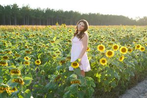 Friends enjoying a carefree summer evening photoshoot among rows of tall sunflowers.