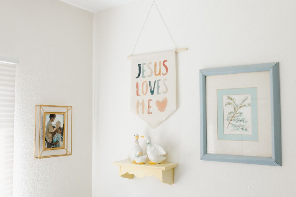 A series of framed wall art and decorative pieces arranged in a gallery wall style against a white wall.