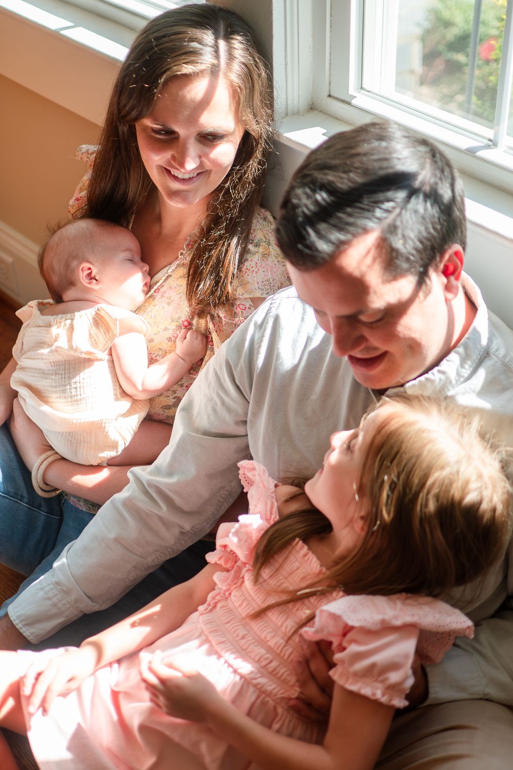 A tender family moment captured in a series of five photos showing loving interactions near a bright window.
