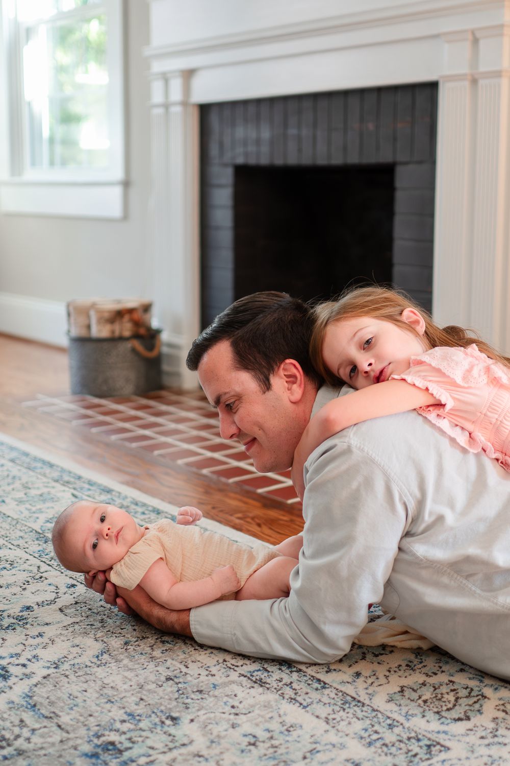 A series of photos showing a parent and child lying on a patterned carpet near a fireplace.