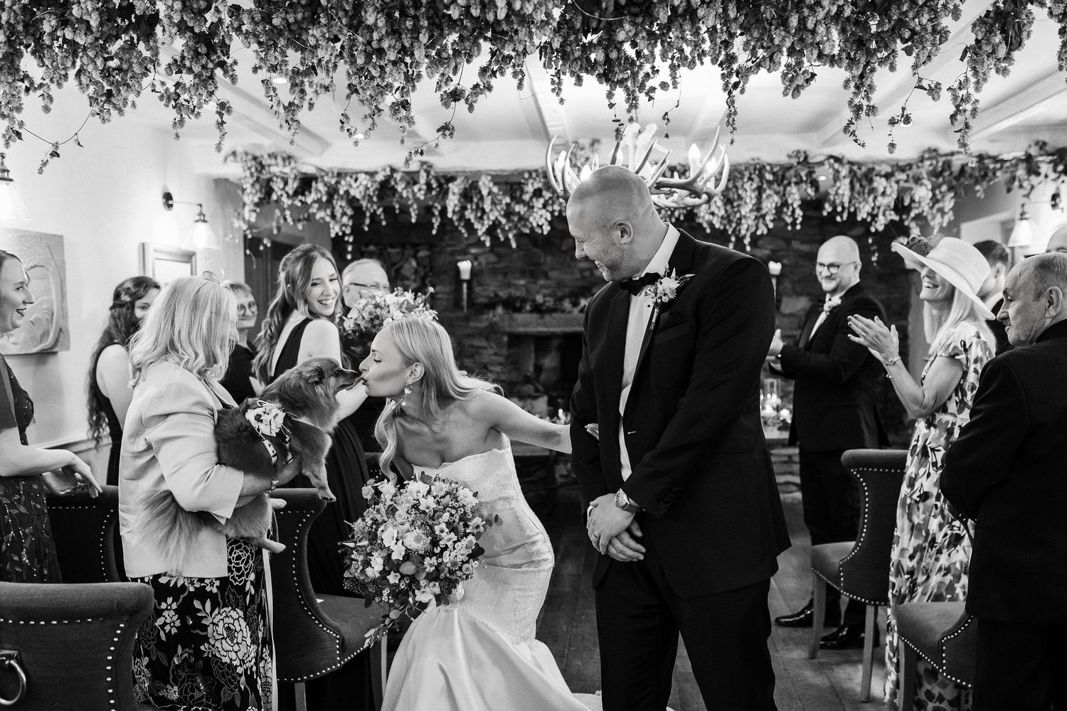 Wedding guests dance and celebrate under strings of outdoor lights during an evening reception celebration.