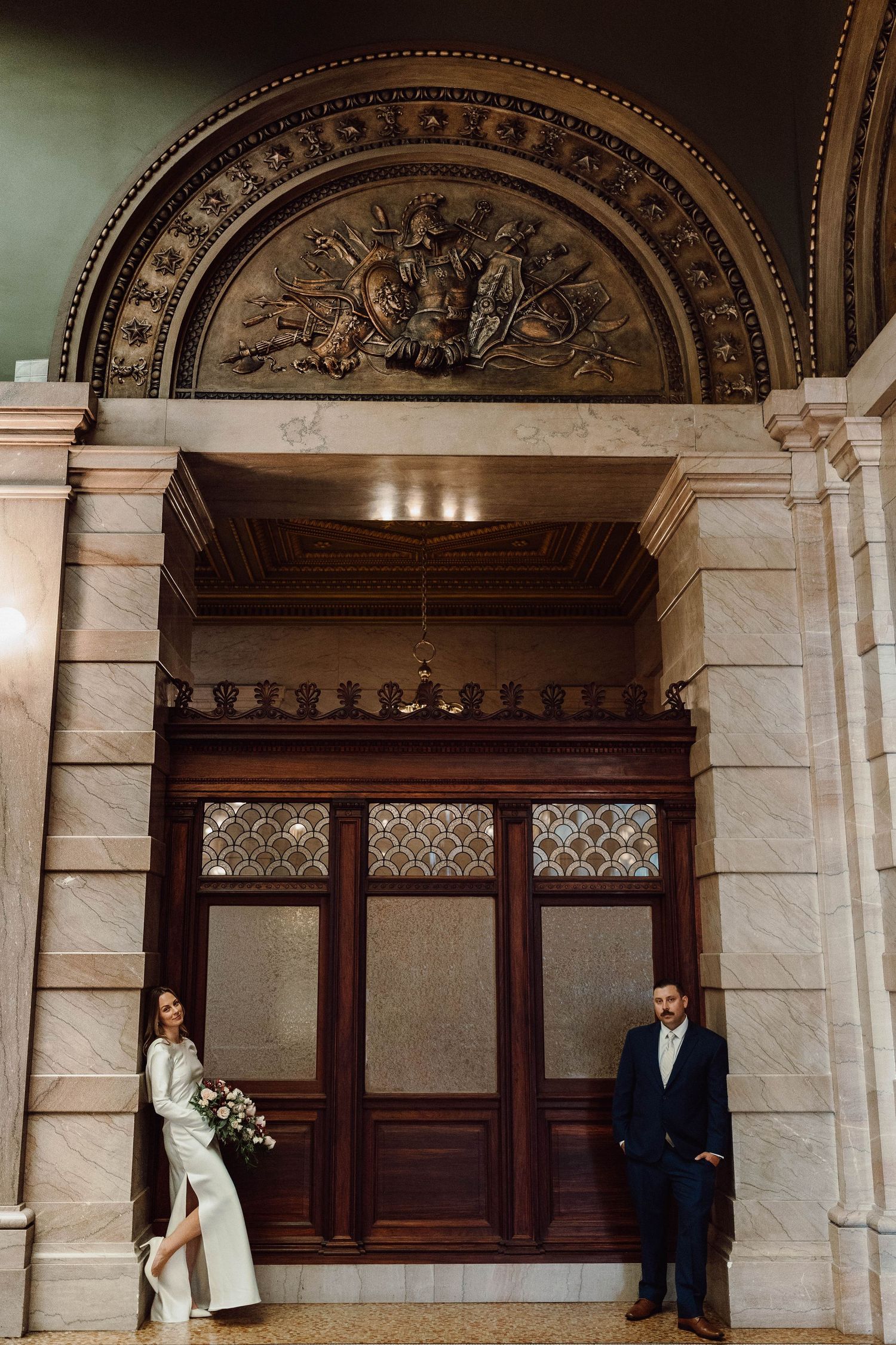 Elegant architectural entrance with ornate carved stone archway and wooden doors.