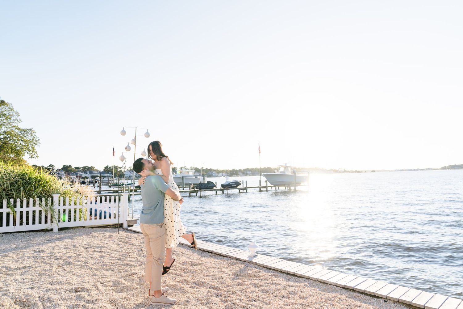 A romantic seaside engagement photoshoot with a couple walking along the water.