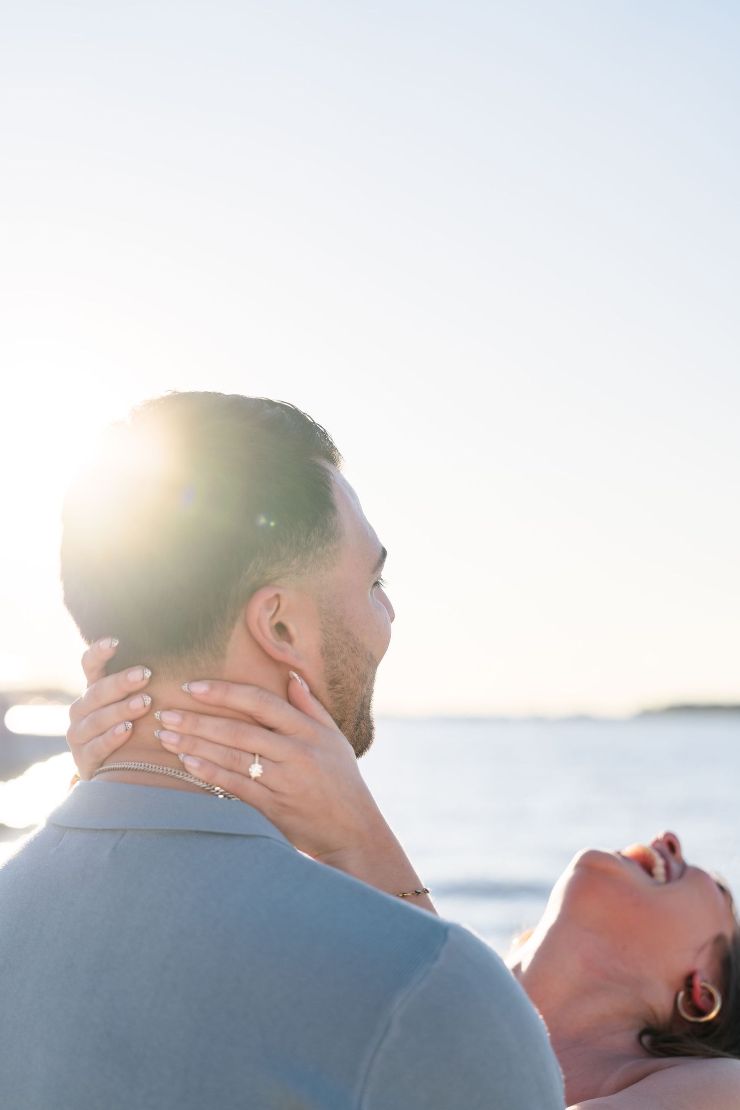 A tender moment captured between a couple during sunset by the ocean.