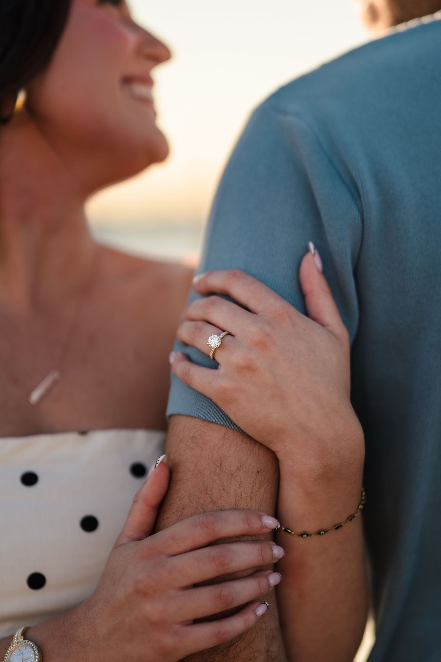 Close-up details of hands and engagement ring during a romantic moment.