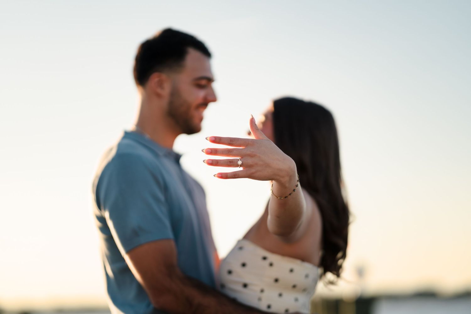 A romantic seaside moment between a couple during golden hour.