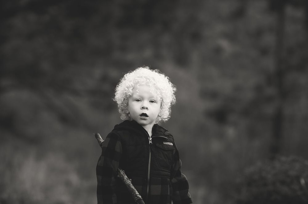 A series of black and white portrait photos showing a person in various poses and expressions.