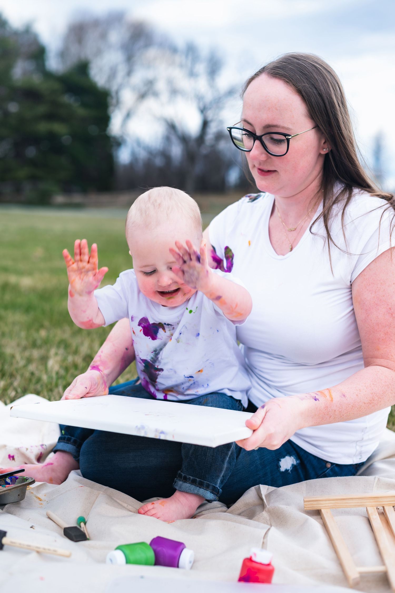 Colorful finger painting activity creates messy fun during an outdoor art session on a spring day.