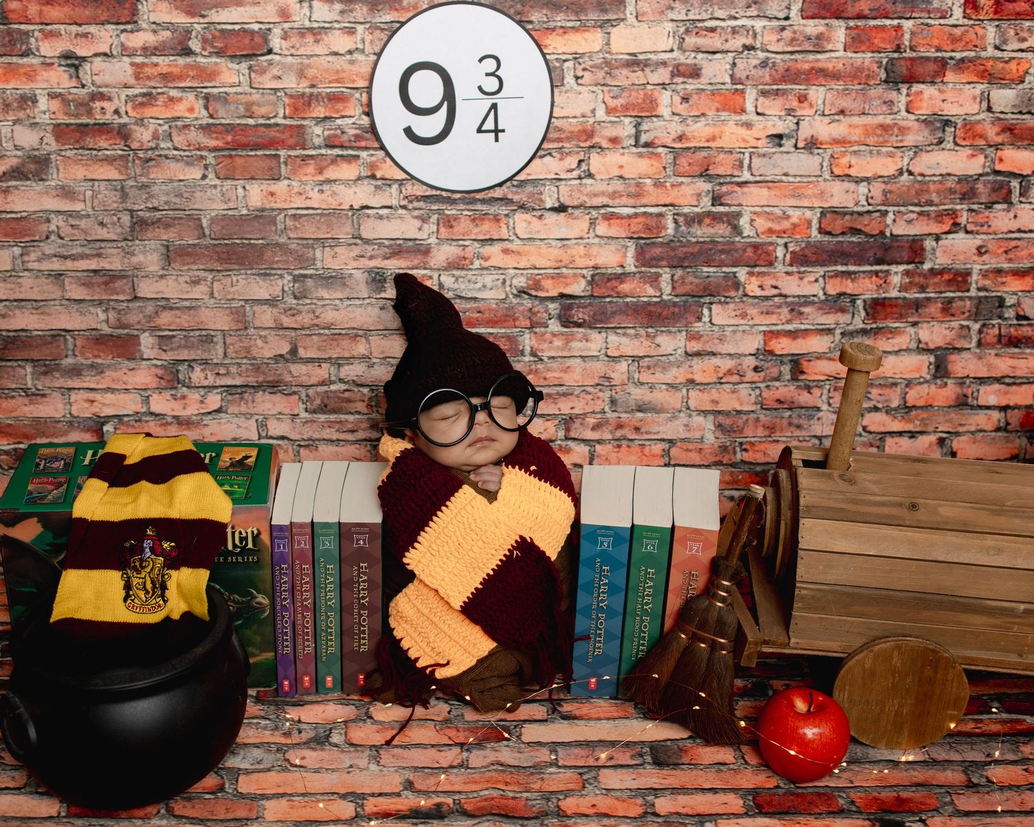 A magical Platform 9 3/4 themed scene with a cauldron, wand, apple, and Harry Potter style decor against a brick wall.