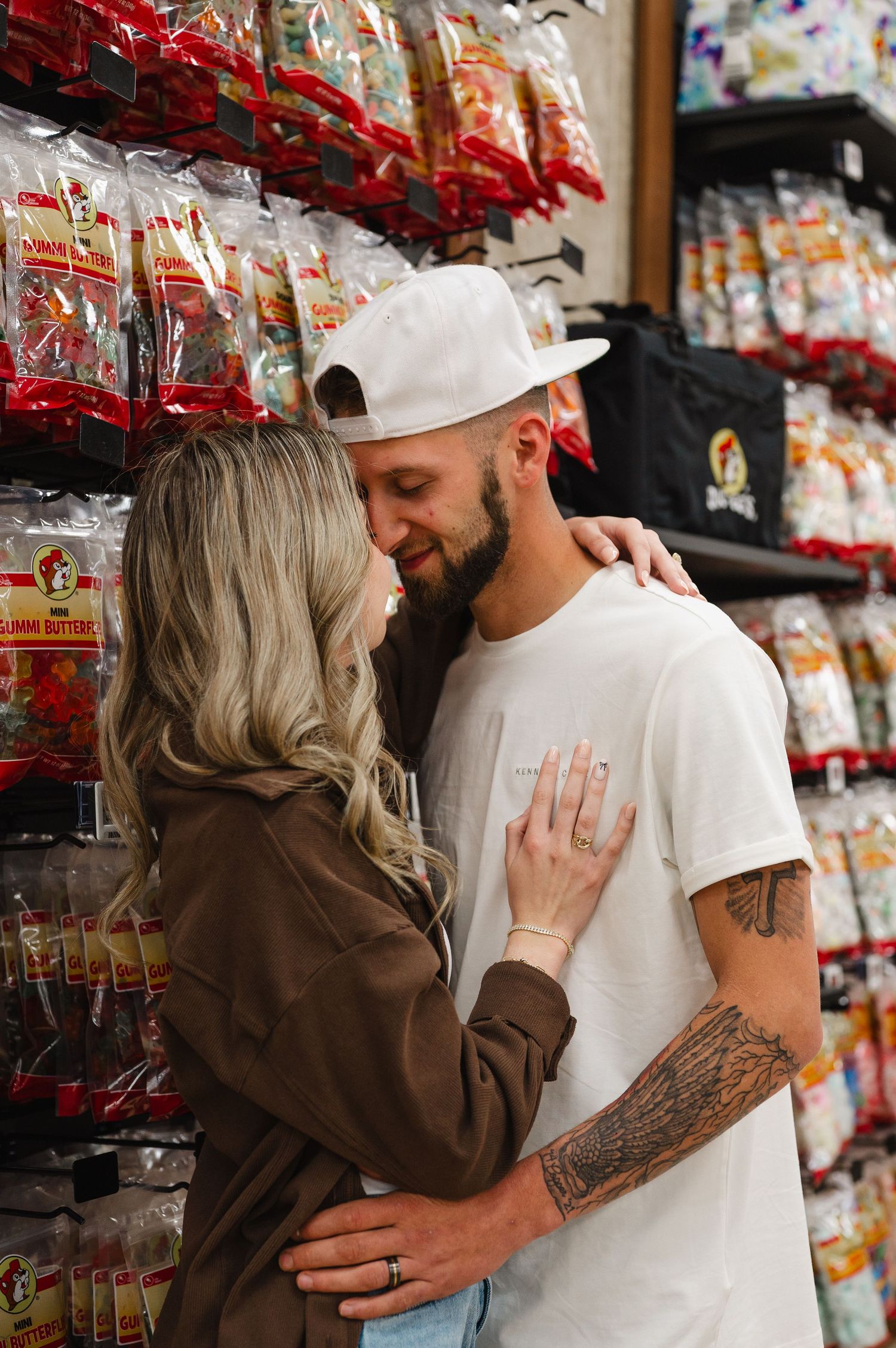 A romantic moment in a grocery store aisle with snack bags visible on shelves in the background.