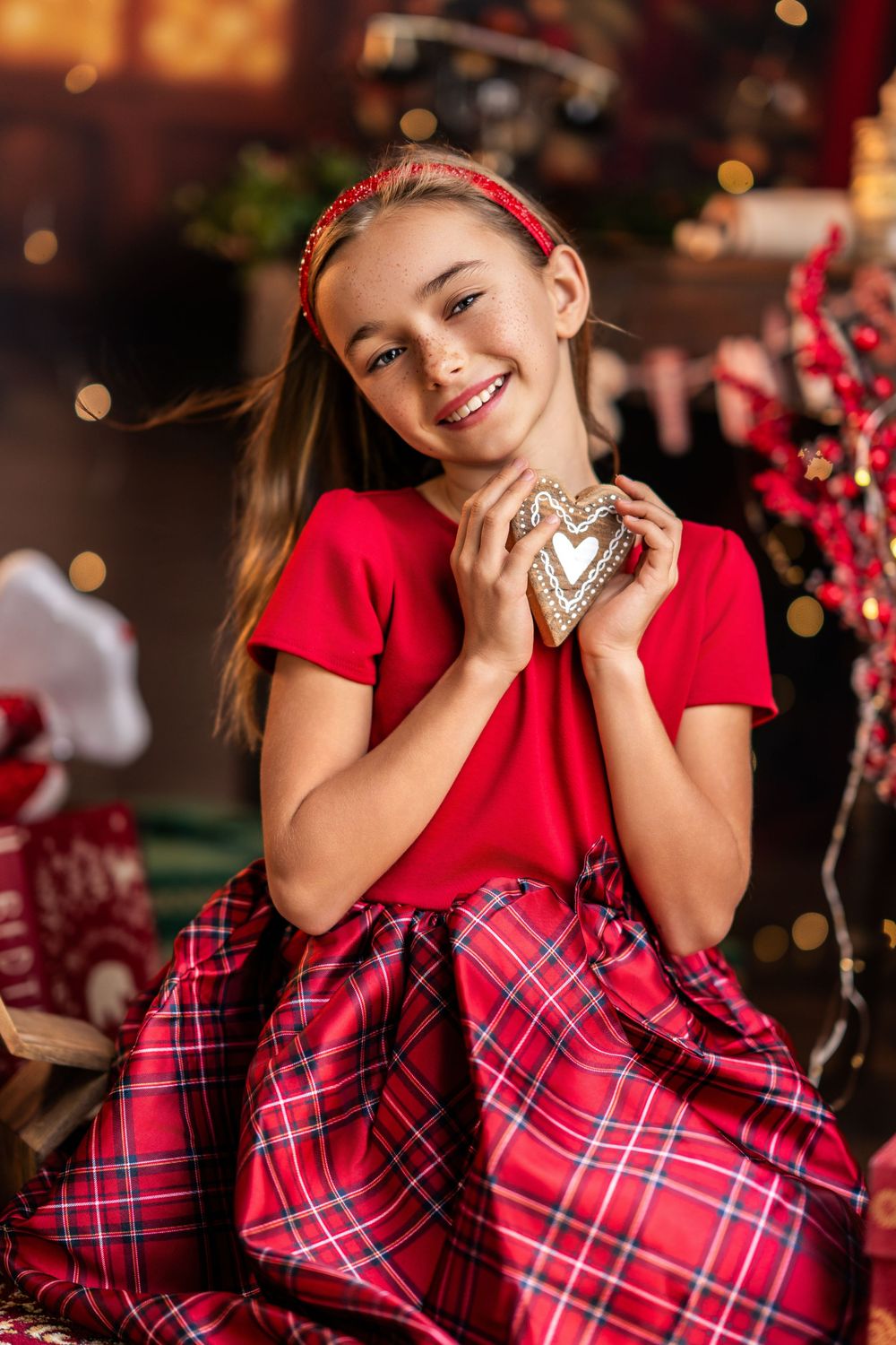 A series of festive holiday portraits showing someone in red and plaid clothing against a warm bokeh background.