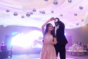 Couple dancing under dramatic lighting and hanging crystal decorations at wedding reception.