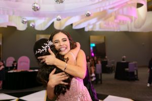 Celebratory moment between two guests in formal attire at evening event.