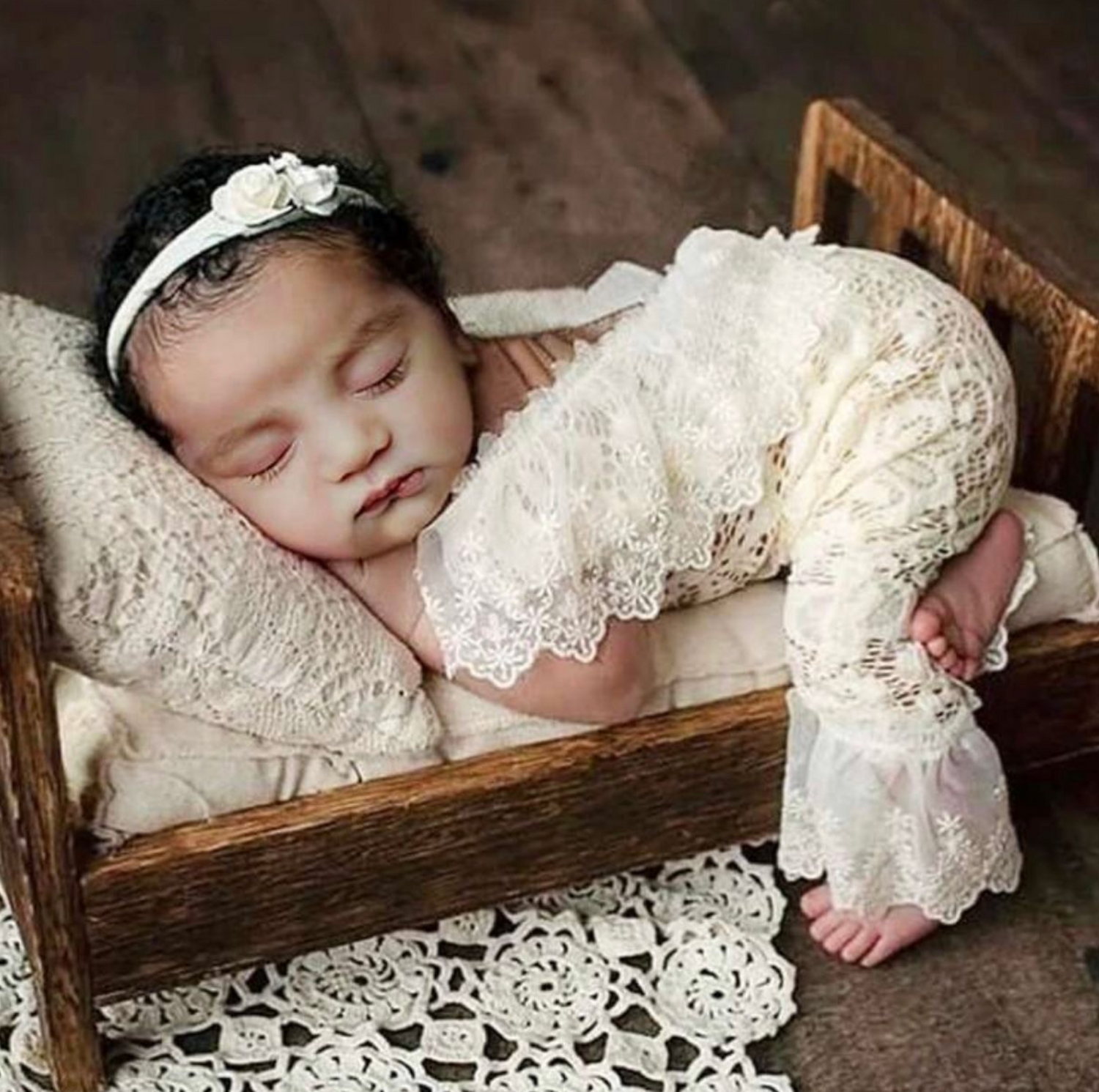Vintage wooden crate with delicate lace details used as newborn photography prop.