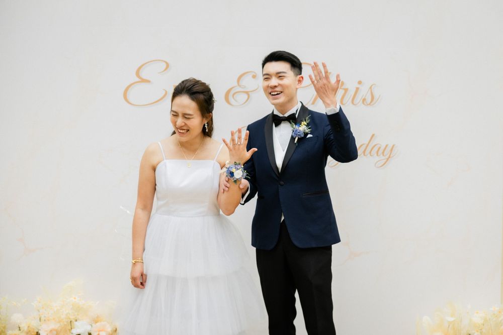 Joyful newlyweds Eva and Chris wave to guests at their elegant wedding reception.