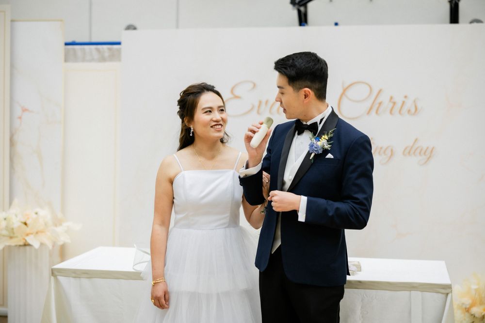 Bride and groom sharing a tender moment at their wedding reception in front of an elegant backdrop.