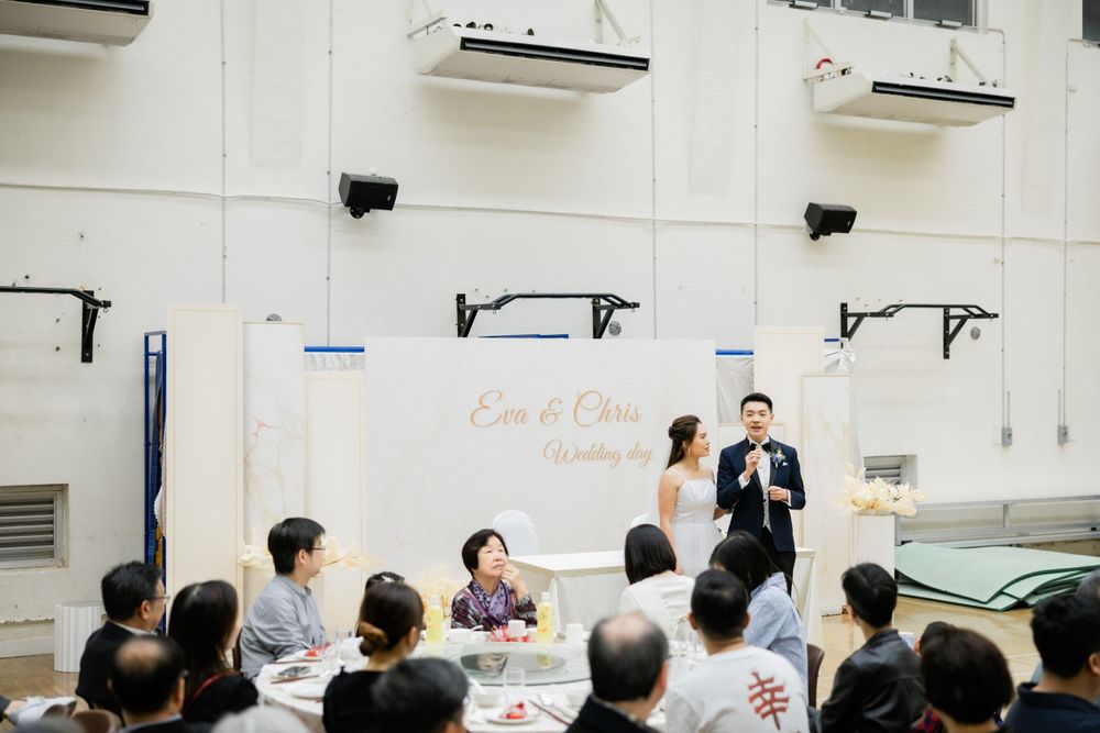 Wedding couple standing at the altar addressing seated guests during their reception ceremony.