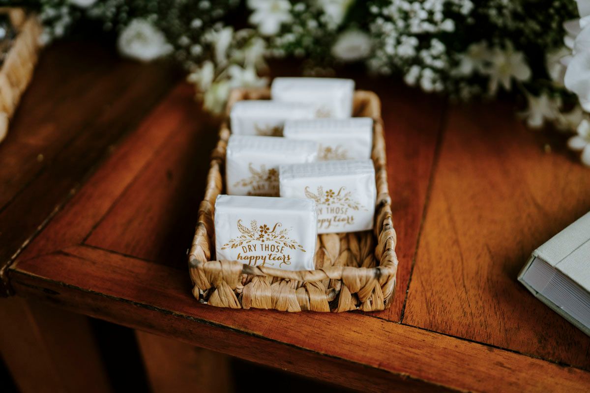 Wedding place cards decorated with white flowers arranged on a wooden surface.