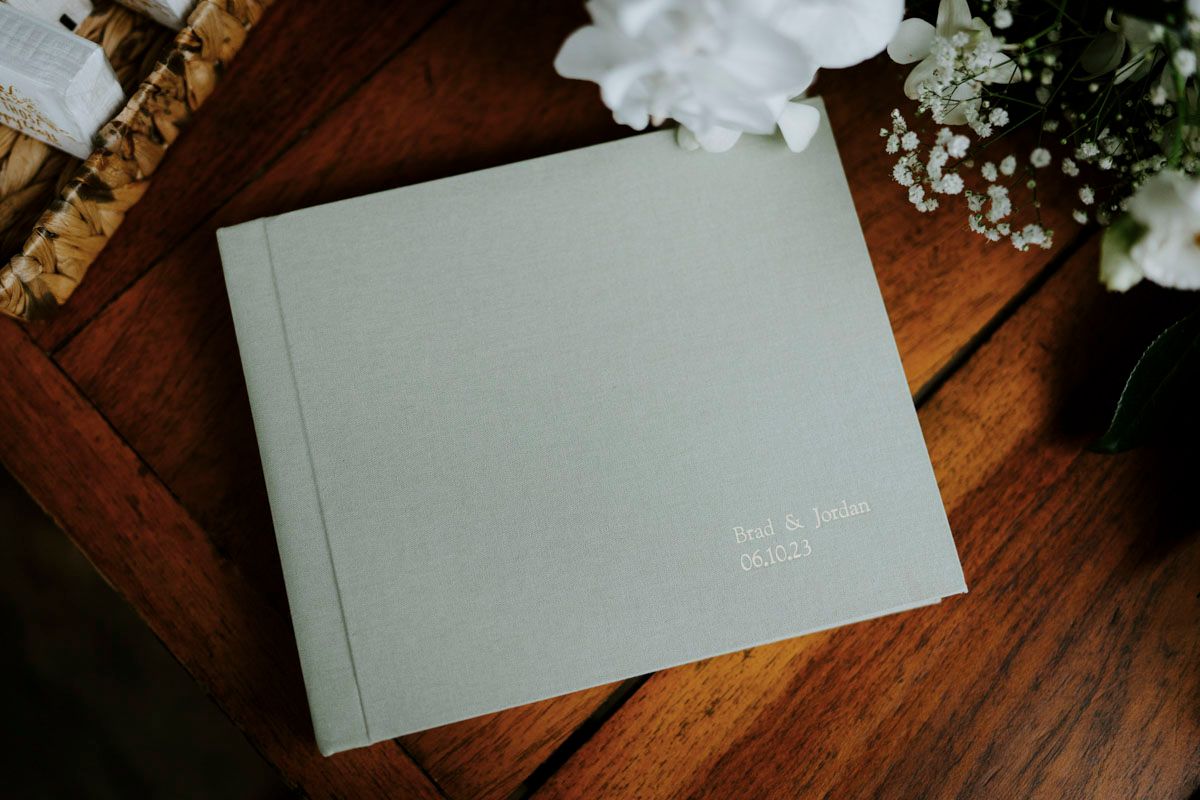 Elegant white place cards and envelopes arranged on a rustic wooden table.