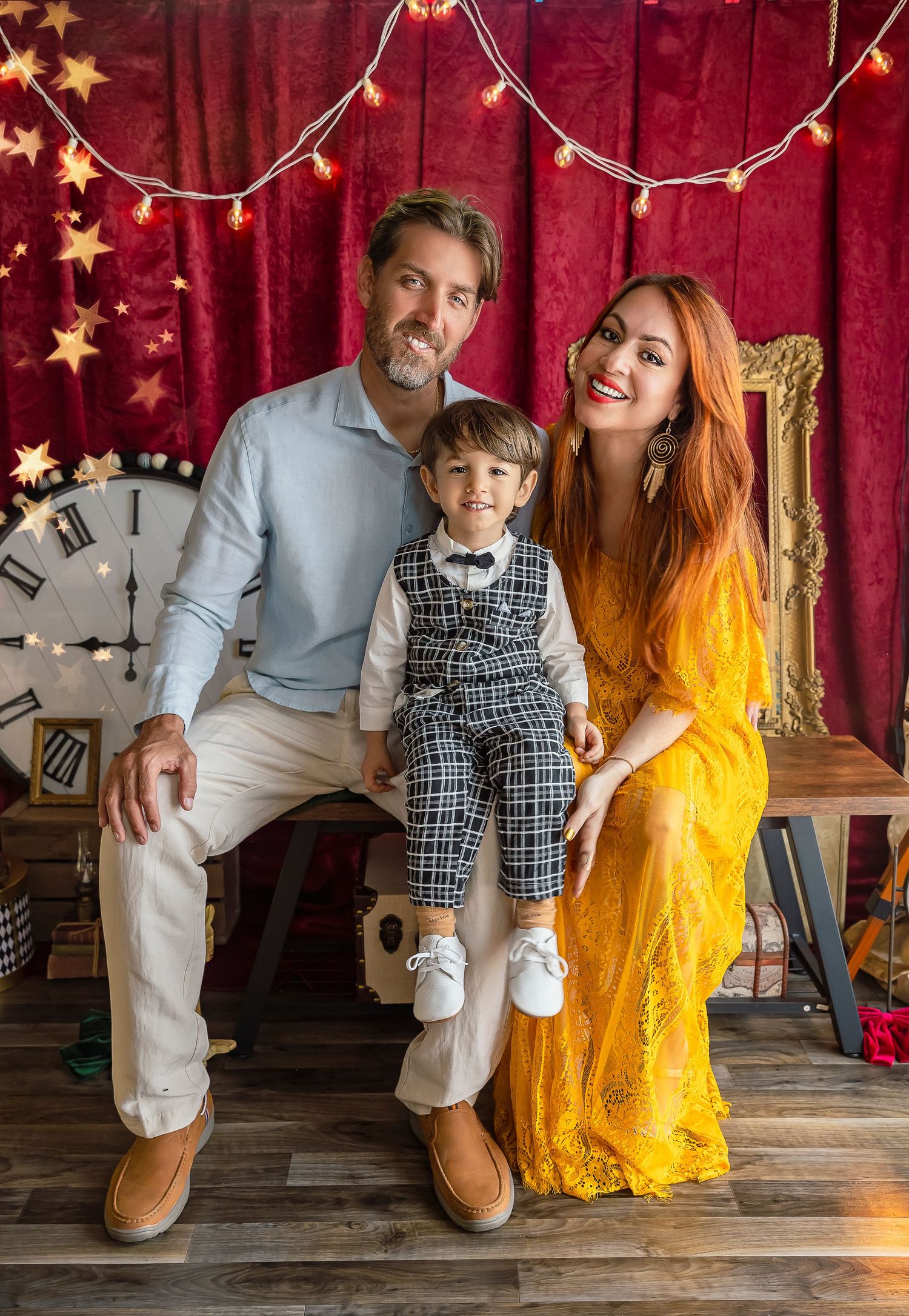 family portrait with mom dad and child sitting on their lap child is 3 years old