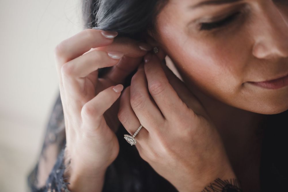 Person in a dark setting talking on a mobile phone while looking down with a thoughtful expression.