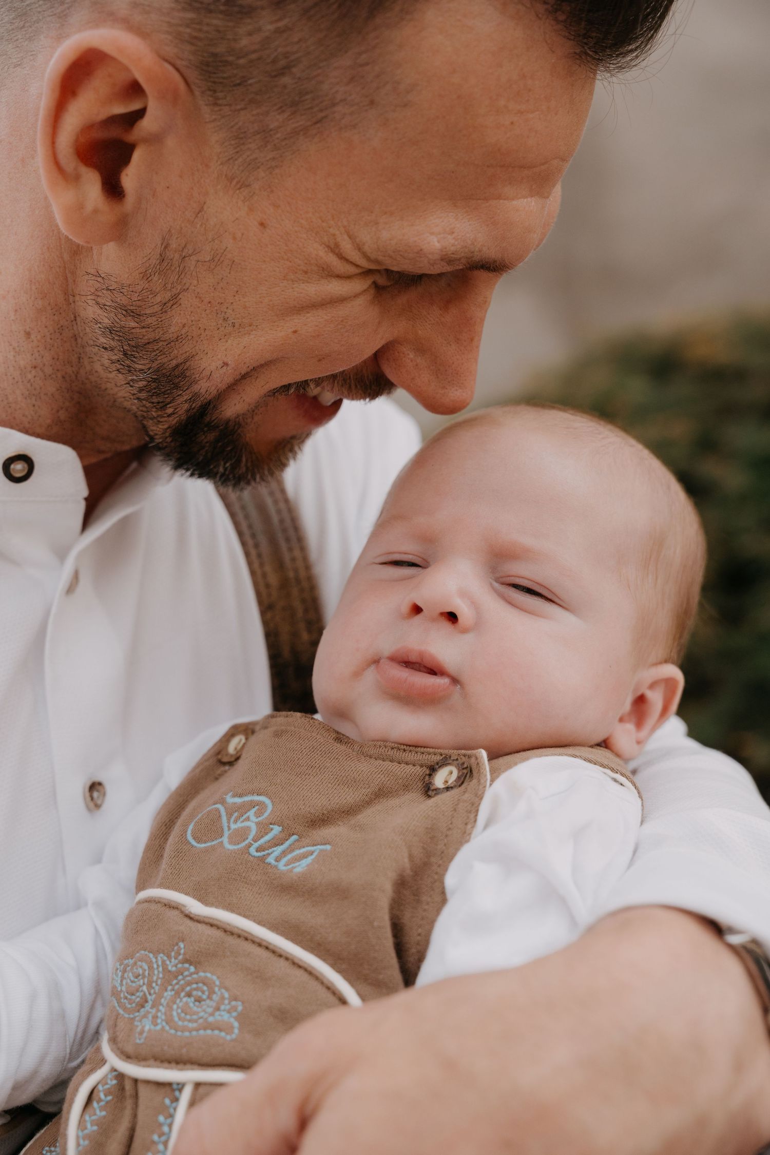 A tender moment between parent and baby wearing a brown outfit, shown in a series of connected photos.