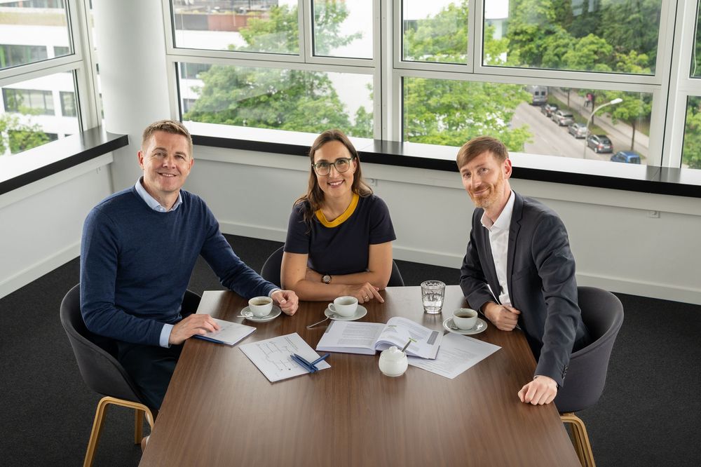 Business team collaborating at a modern office conference table during a meeting.