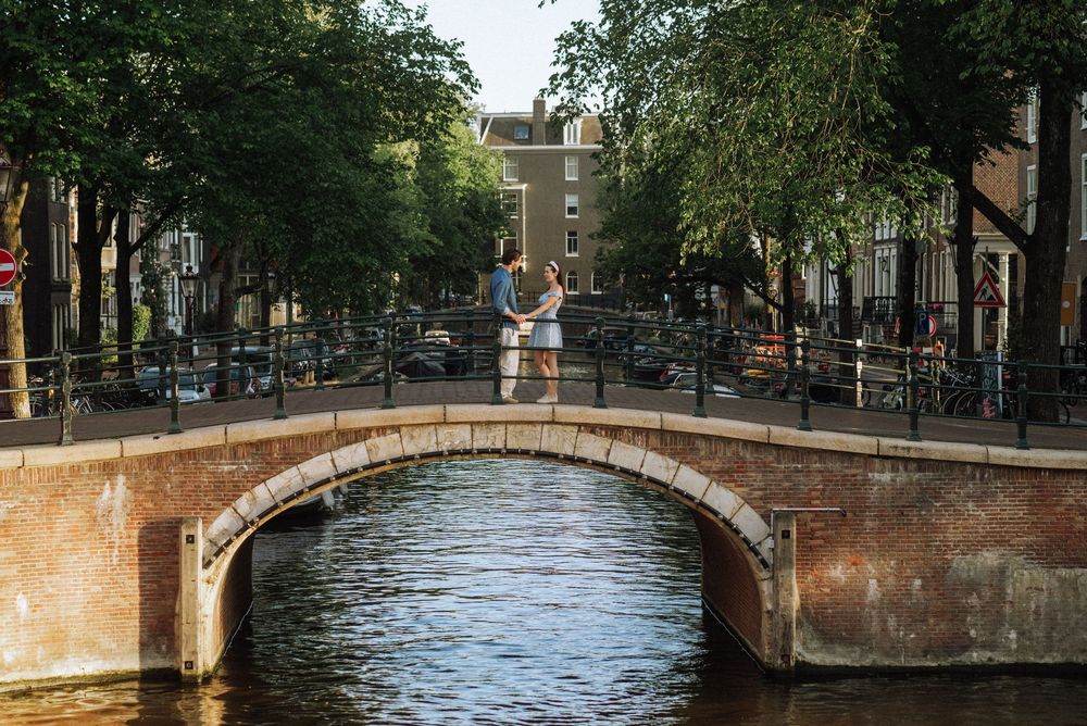 Scenic view of Amsterdam canal with historic bridges and architecture.