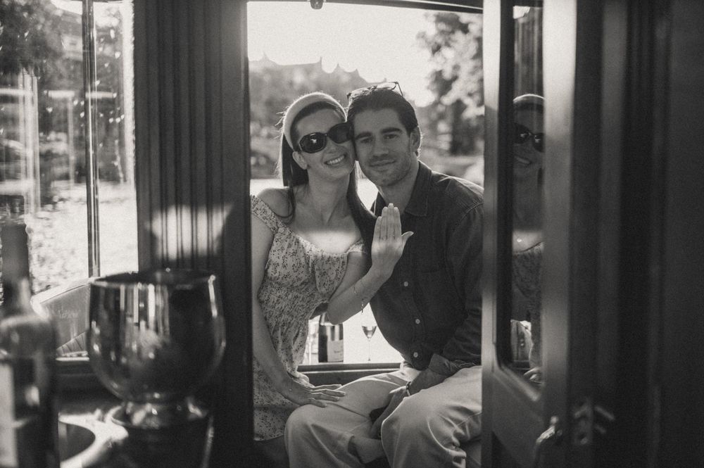 Black and white candid moment captured through window reflections.