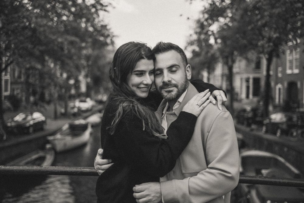 A couple shares an intimate moment along Amsterdam's canal streets.