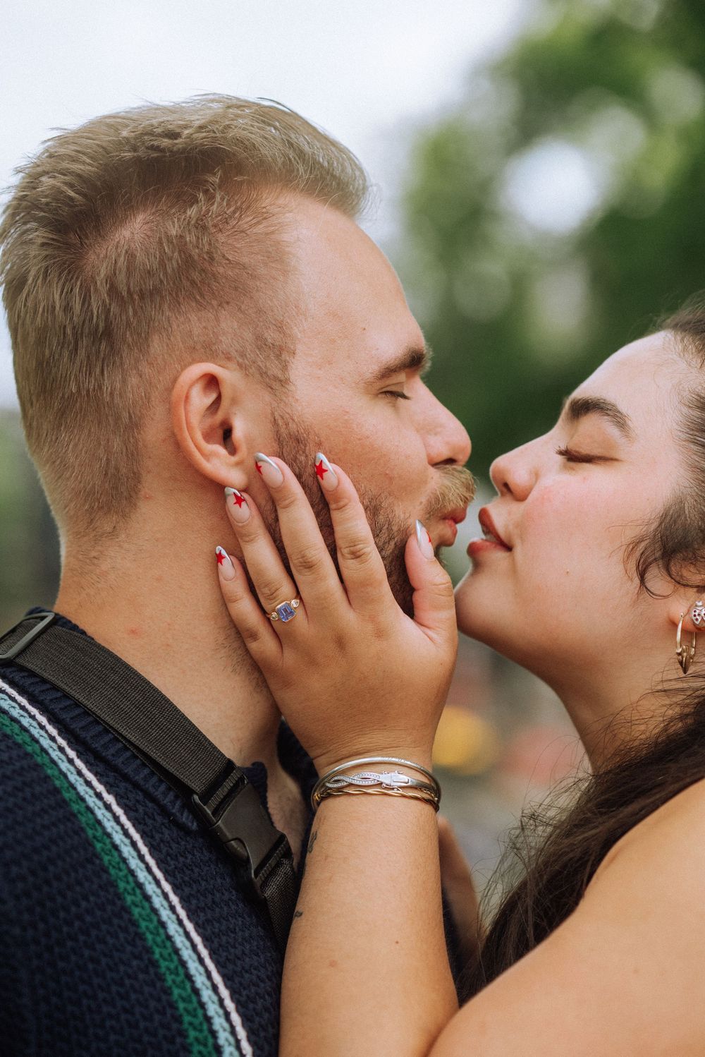 Romantic close-up moment between a couple sharing a tender kiss outdoors.