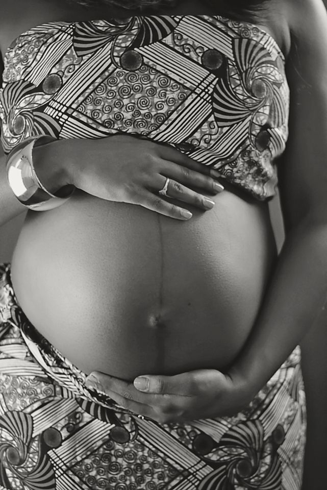 Black and white photo series showing a pregnant belly with hands gently cradling it in different poses.