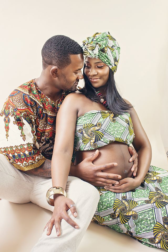 A couple in colorful African print outfits share intimate moments in a romantic maternity photoshoot.