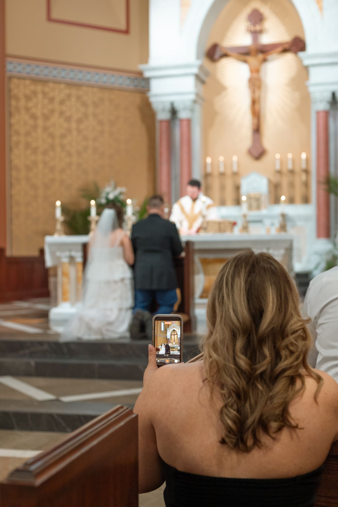 A series of photos showing a person's back while taking pictures in a church with ornate decorations and crosses.