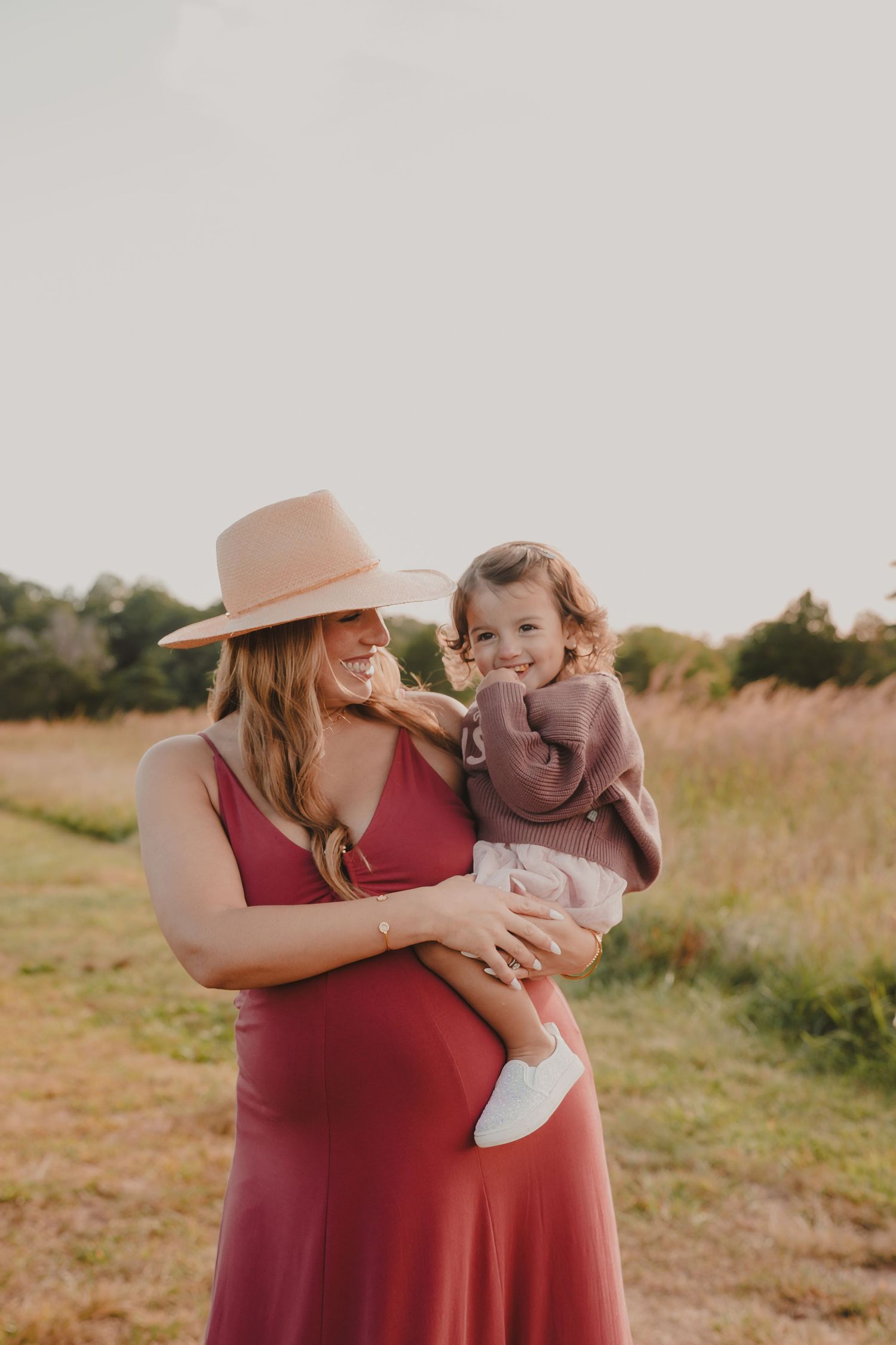 A tender moment between parent and child playing together in a sunlit field.