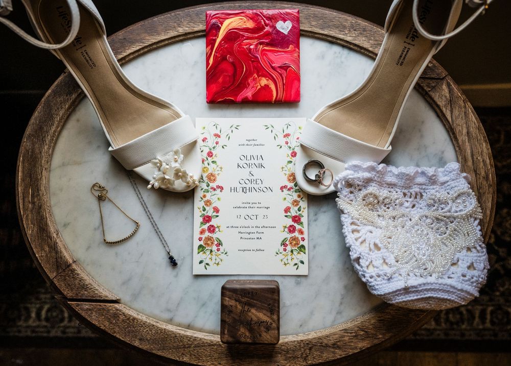 Wedding invitation suite with floral design and lace details displayed on antique silver trays.