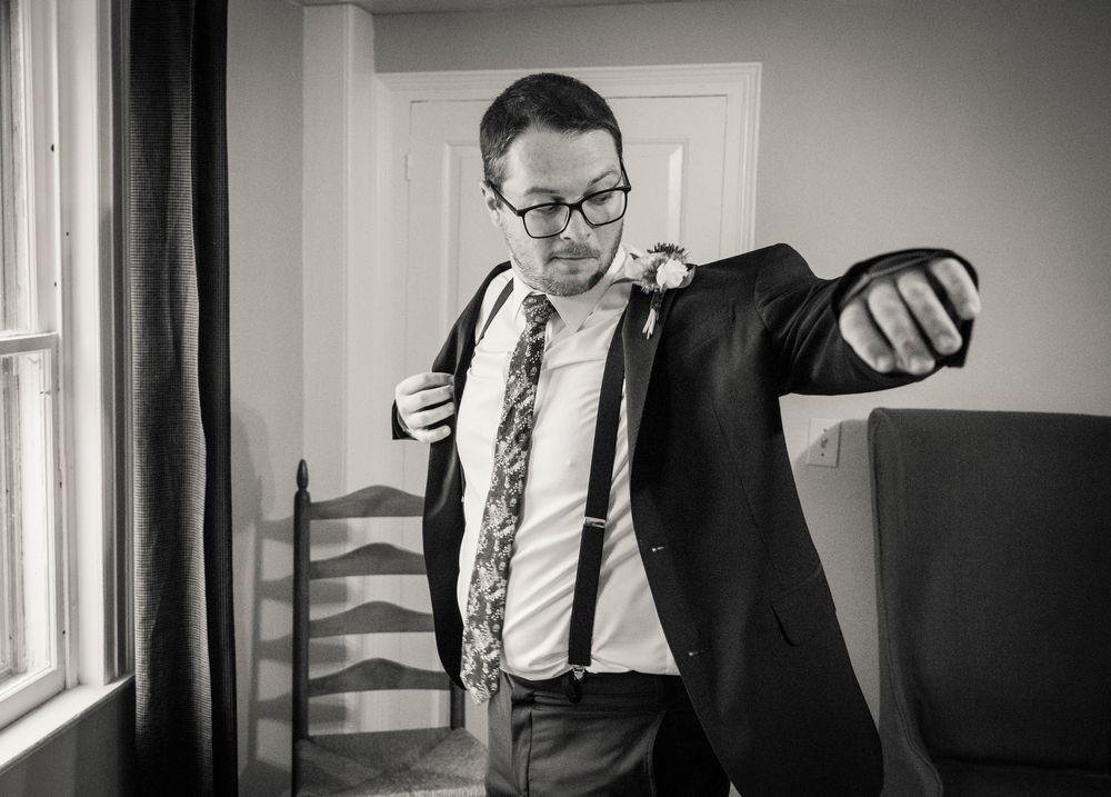 Black and white photo of men in suits preparing for a formal event.
