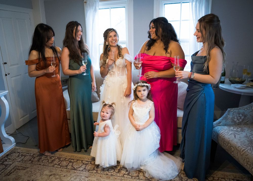 Wedding party members gather in a room for pre-ceremony preparations and conversations.