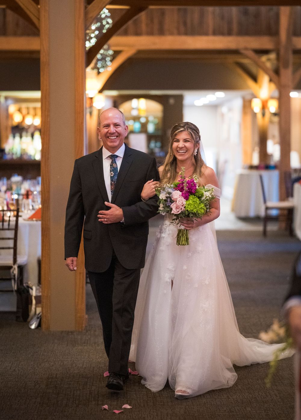 A sequence of wedding photos showing a bride in a white gown walking down an indoor hallway with an escort.