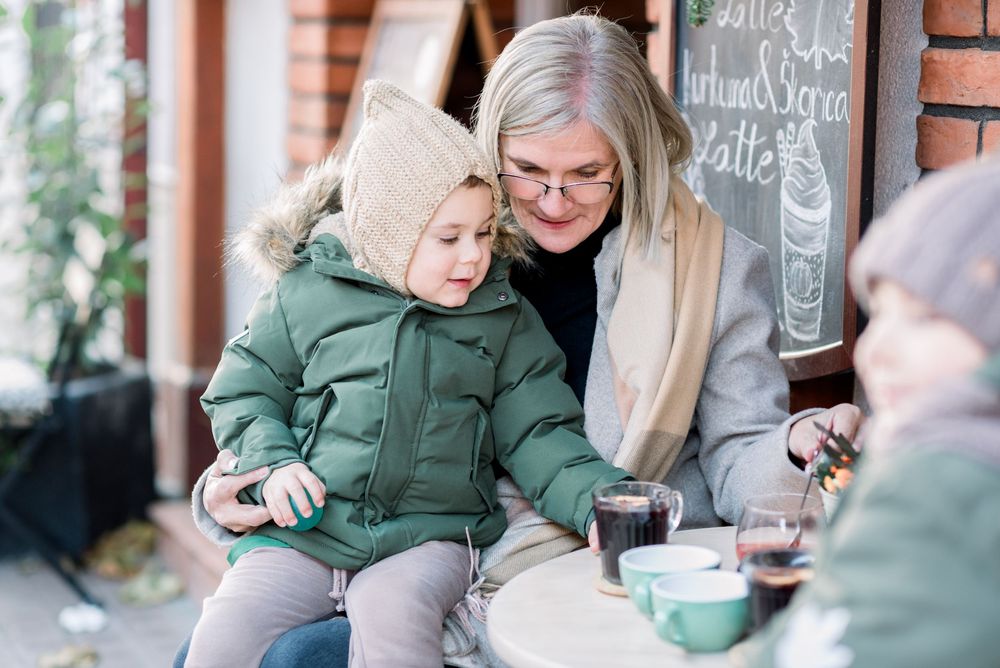 Cozy winter cafe scene with warm drinks and conversation against brick wall backdrop.