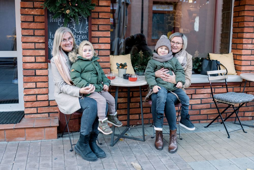 Small group enjoying outdoor cafe seating with warm drinks and winter attire.