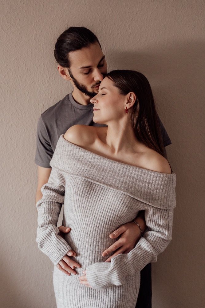 A romantic couple in matching gray sweaters embrace tenderly in a series of intimate portrait photos.