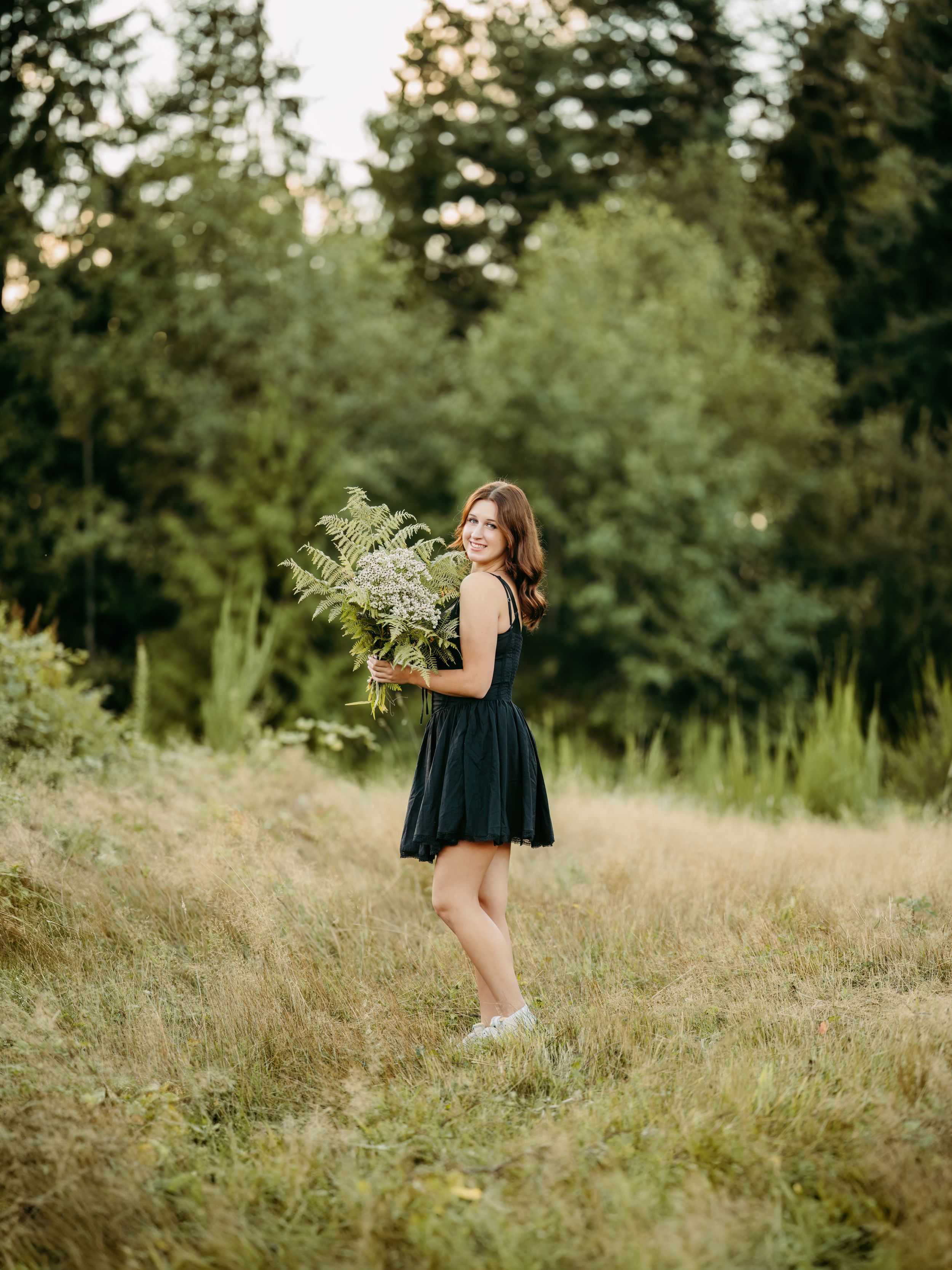 A series of photos showing someone in a black dress dancing and twirling through a sunlit meadow with tall grass.