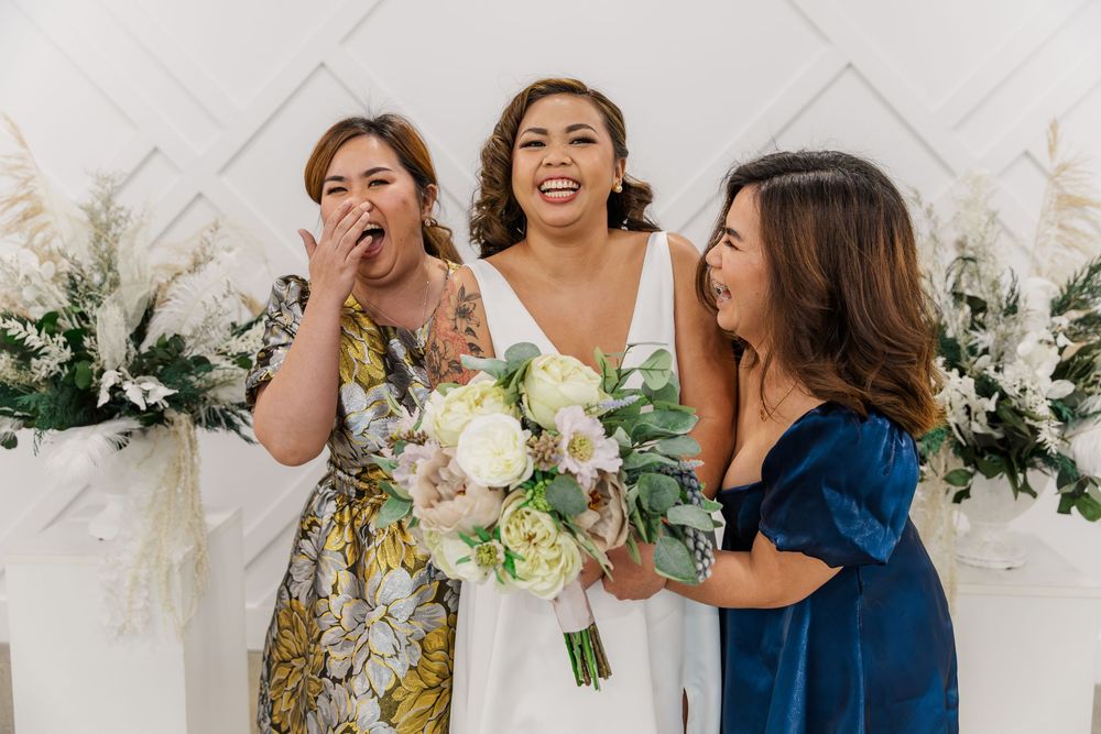 Bride and her friends sharing joyful laughter during wedding celebrations at DTK Chapel in downtown Kitchener, Ontario.