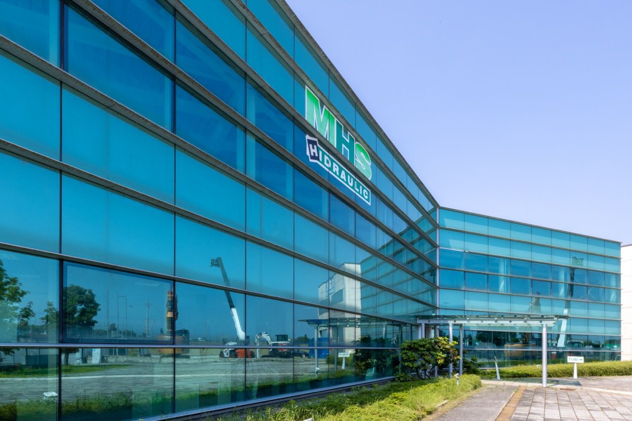 Panoramic view of a large commercial building with blue-tinted glass facade and MRS signage.